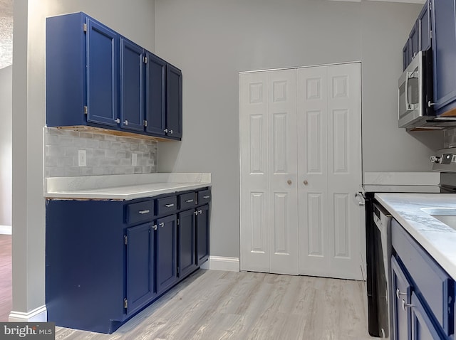 kitchen with backsplash, appliances with stainless steel finishes, light wood-type flooring, and blue cabinets