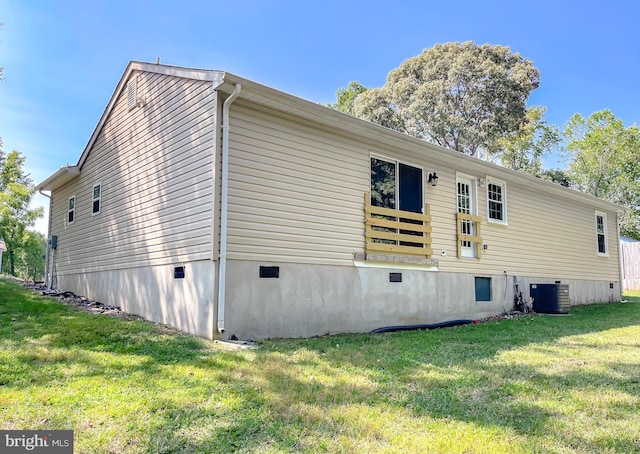 view of side of home with a lawn and cooling unit