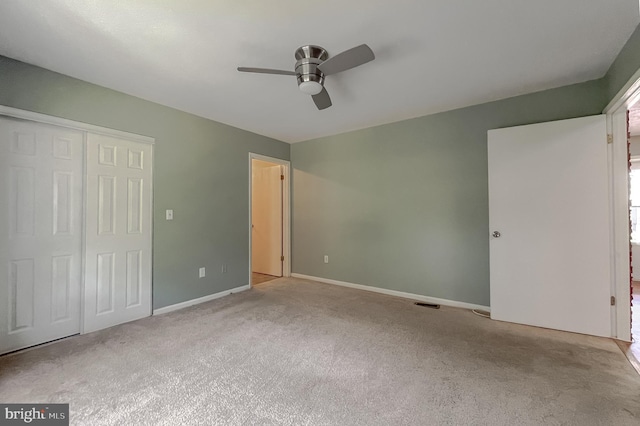 unfurnished bedroom with light carpet, ceiling fan, and a closet