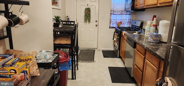 kitchen featuring dark stone counters and appliances with stainless steel finishes