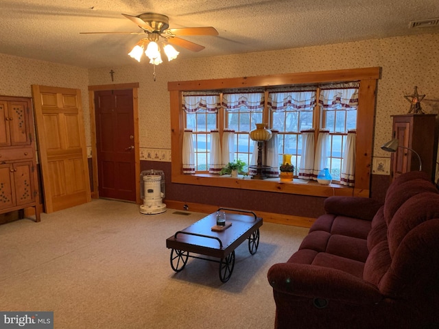 carpeted living room with ceiling fan and a textured ceiling