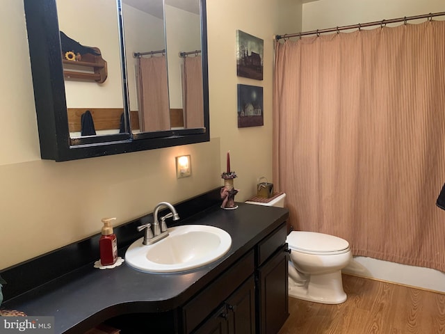 bathroom featuring toilet, vanity, a shower with shower curtain, and hardwood / wood-style floors