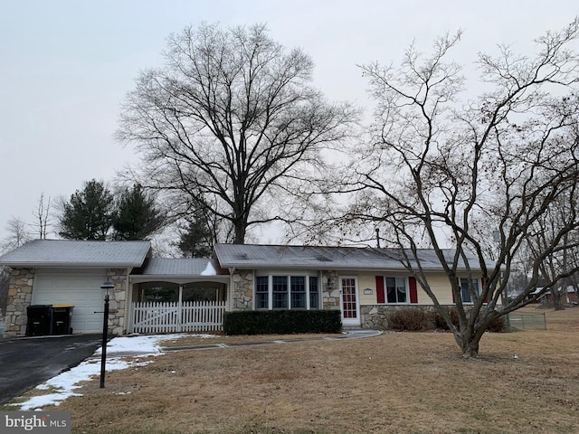 ranch-style house featuring a garage and a front lawn