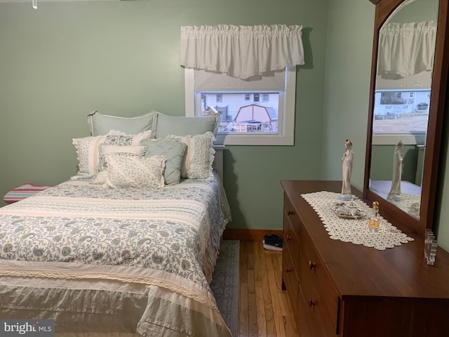 bedroom with multiple windows and wood-type flooring