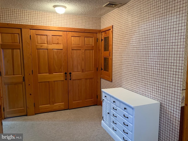 interior space with light colored carpet and a textured ceiling