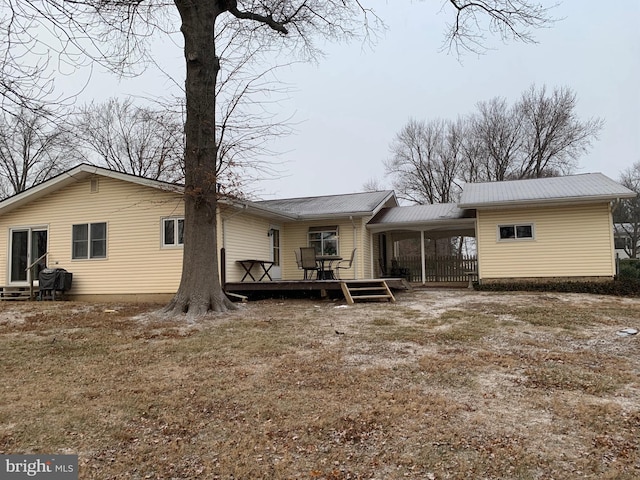 rear view of house featuring a deck and a yard