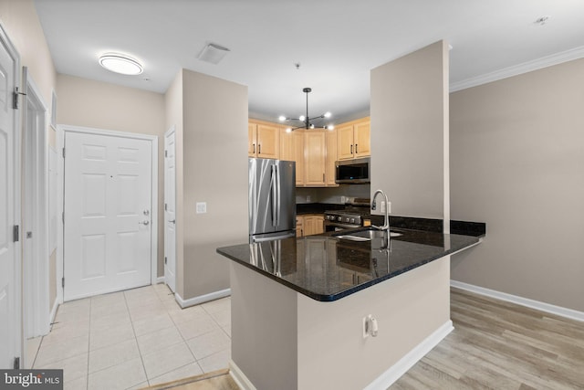 kitchen featuring stainless steel appliances, kitchen peninsula, dark stone counters, light brown cabinetry, and decorative light fixtures