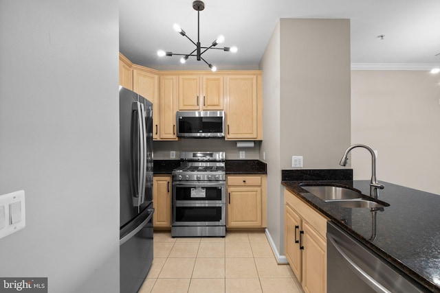 kitchen with dark stone countertops, stainless steel appliances, light tile patterned floors, pendant lighting, and sink