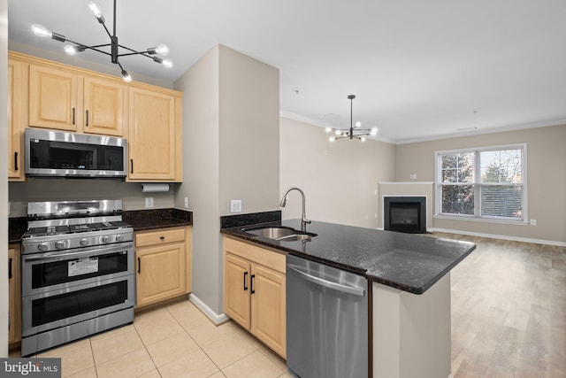 kitchen featuring appliances with stainless steel finishes, hanging light fixtures, kitchen peninsula, and sink