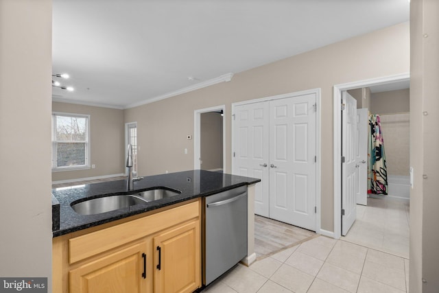 kitchen with dark stone countertops, light tile patterned floors, light brown cabinetry, sink, and stainless steel dishwasher