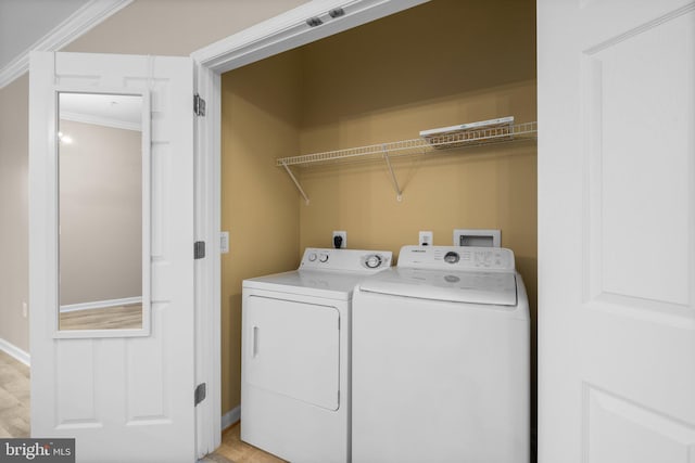 laundry area with ornamental molding and independent washer and dryer