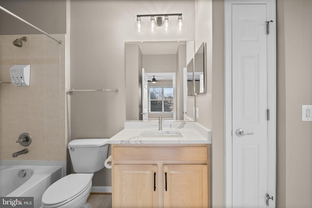 full bathroom with toilet, tiled shower / bath, ceiling fan, and vanity