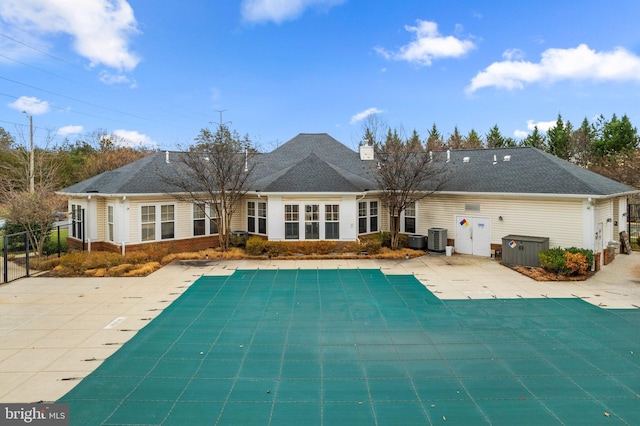 back of property featuring a covered pool, central AC, and a patio area