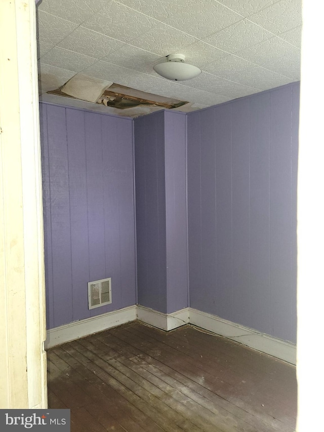 unfurnished room with dark wood-type flooring