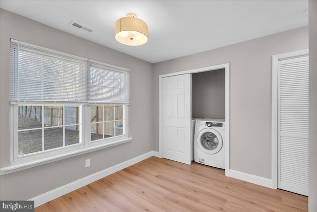 washroom with washer / dryer, light hardwood / wood-style flooring, and a wealth of natural light