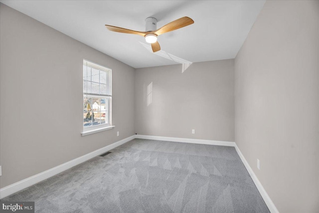 carpeted spare room featuring ceiling fan