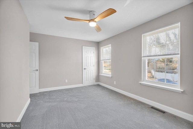 carpeted spare room with ceiling fan