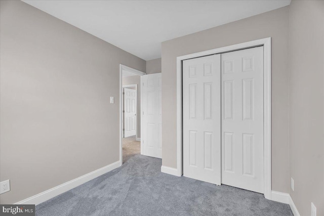 unfurnished bedroom featuring carpet flooring and a closet