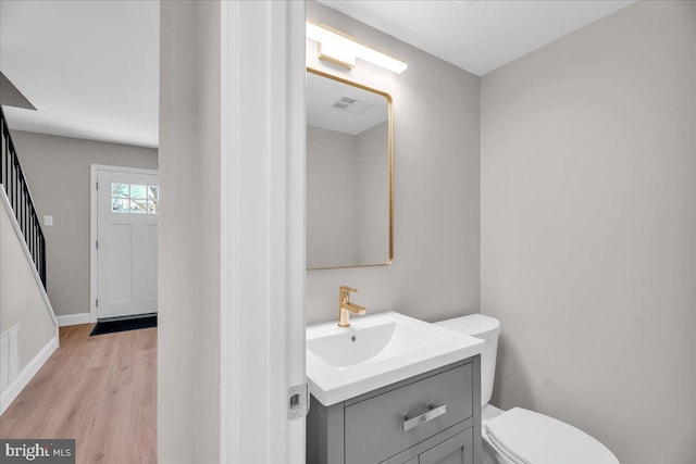 bathroom featuring toilet, wood-type flooring, and vanity