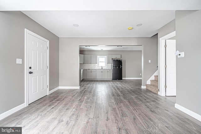 unfurnished living room with ceiling fan and light hardwood / wood-style flooring