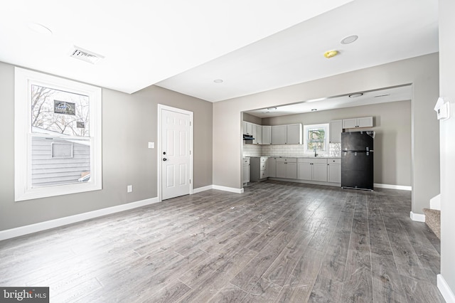 unfurnished living room featuring light wood-type flooring and sink