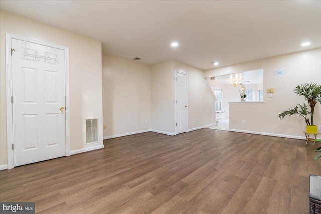 unfurnished living room with a notable chandelier and hardwood / wood-style flooring