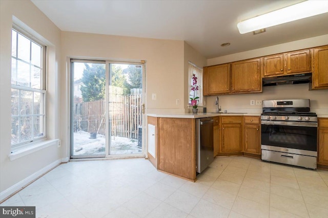 kitchen with stainless steel appliances, plenty of natural light, sink, and kitchen peninsula