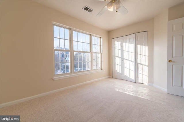 carpeted spare room featuring ceiling fan