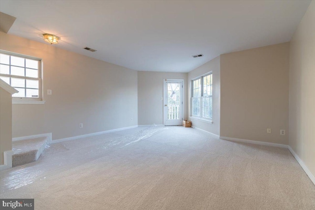 spare room featuring light carpet