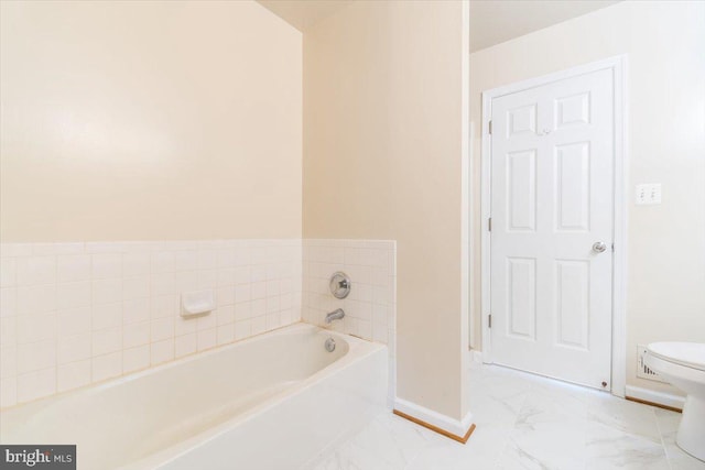 bathroom with a washtub and toilet