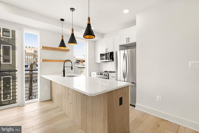 kitchen featuring tasteful backsplash, kitchen peninsula, sink, white cabinetry, and stainless steel appliances