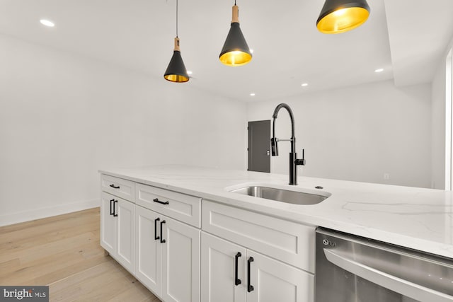 kitchen featuring light stone counters, sink, white cabinetry, and dishwasher