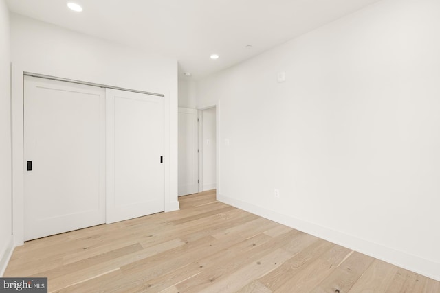 unfurnished bedroom featuring light wood-type flooring and a closet