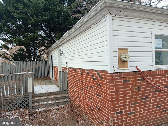 view of side of home with fence and brick siding