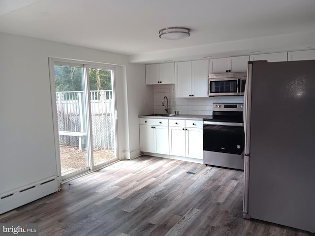 kitchen with appliances with stainless steel finishes, white cabinetry, backsplash, and sink