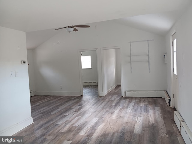 empty room featuring baseboard heating, light wood-type flooring, ceiling fan, and vaulted ceiling