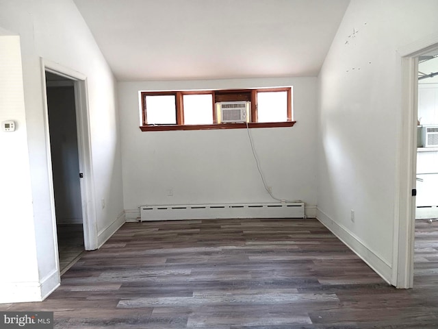 empty room with lofted ceiling, cooling unit, a baseboard heating unit, and dark wood-type flooring