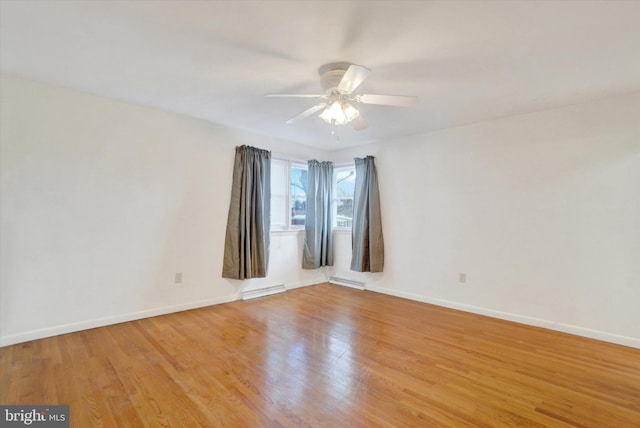 empty room with ceiling fan, light wood-type flooring, and a baseboard radiator