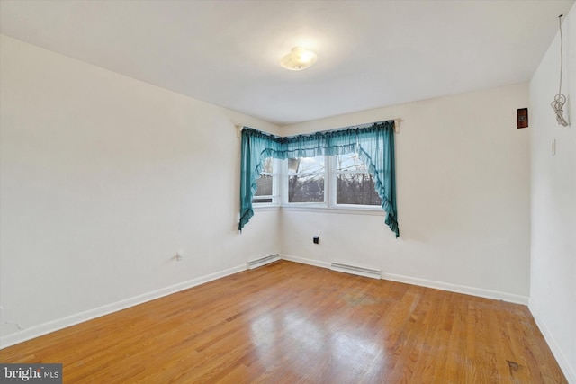 spare room featuring light wood-type flooring and baseboard heating