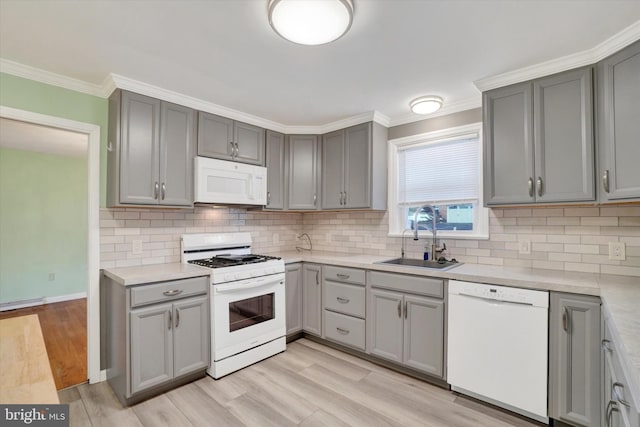 kitchen featuring white appliances, light hardwood / wood-style flooring, sink, backsplash, and gray cabinetry