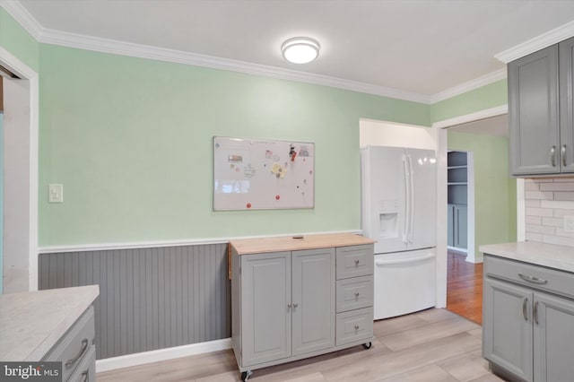 kitchen featuring light hardwood / wood-style floors, white fridge with ice dispenser, gray cabinetry, and ornamental molding