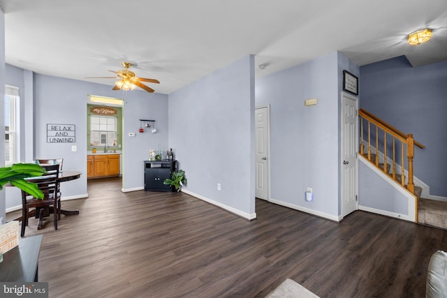 living room featuring ceiling fan and dark hardwood / wood-style flooring