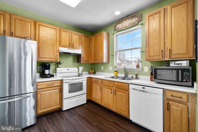 kitchen with appliances with stainless steel finishes, dark hardwood / wood-style floors, and sink