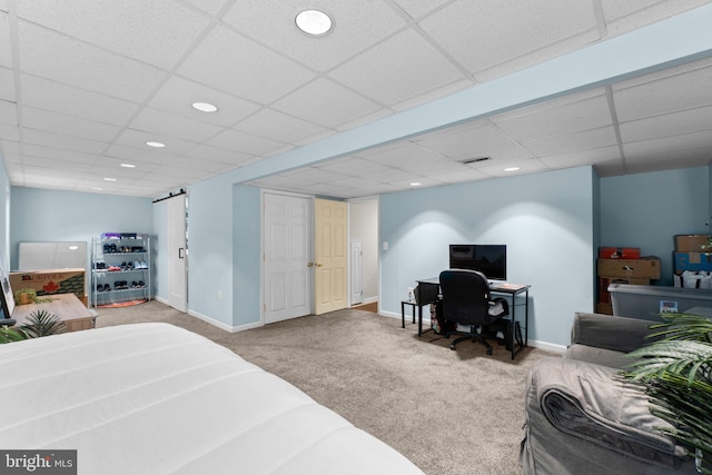 bedroom with light colored carpet and a drop ceiling