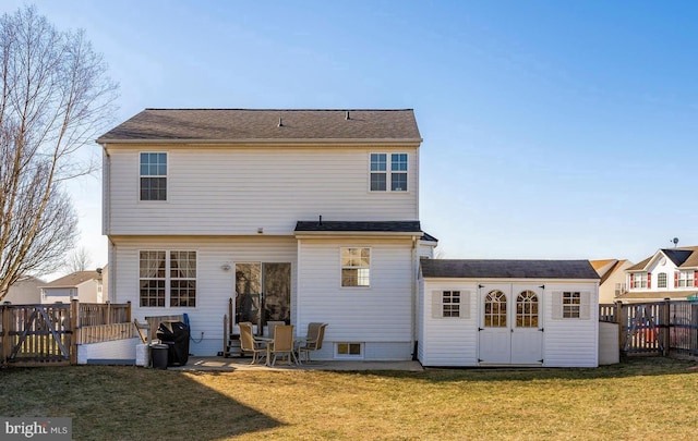 back of property with an outbuilding and a lawn