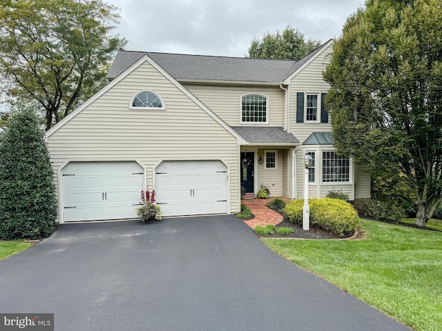 view of front of house with a garage and a front yard