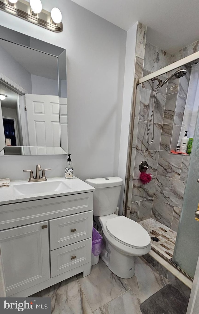 bathroom with toilet, a shower with door, and vanity