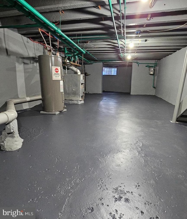 basement featuring electric water heater and heating unit