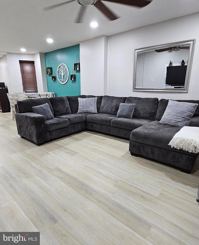 living room with ceiling fan and light hardwood / wood-style flooring