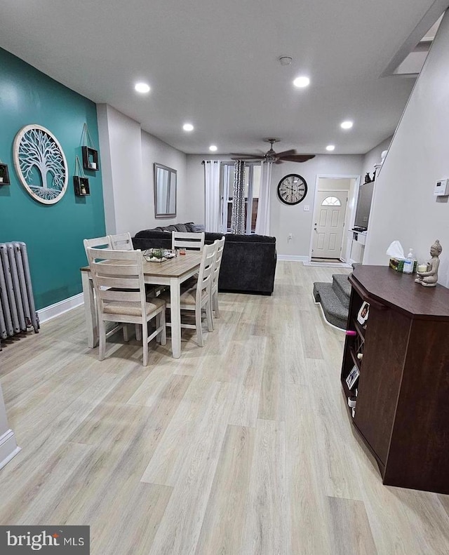 dining area with ceiling fan, light hardwood / wood-style flooring, and radiator heating unit